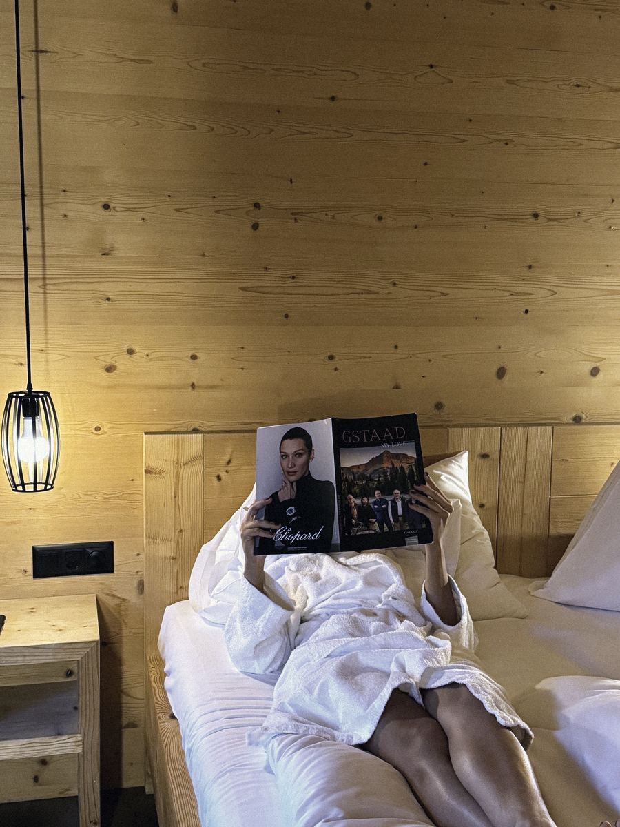 Lecture au lit dans une chambre d'hôtel en bois à Gstaad